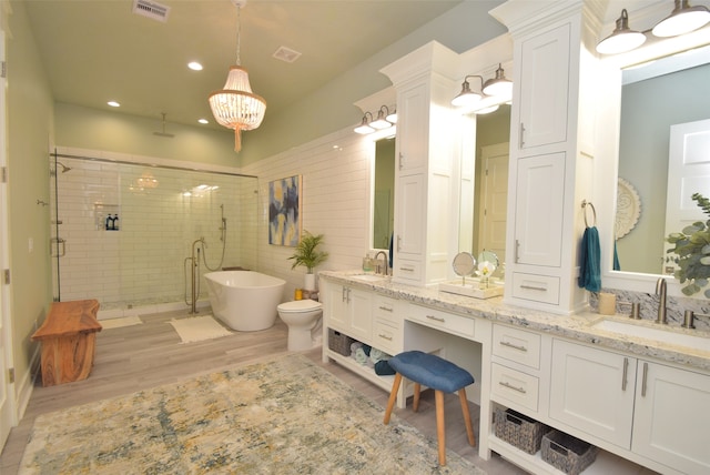 bathroom with double vanity, hardwood / wood-style flooring, an inviting chandelier, and an enclosed shower