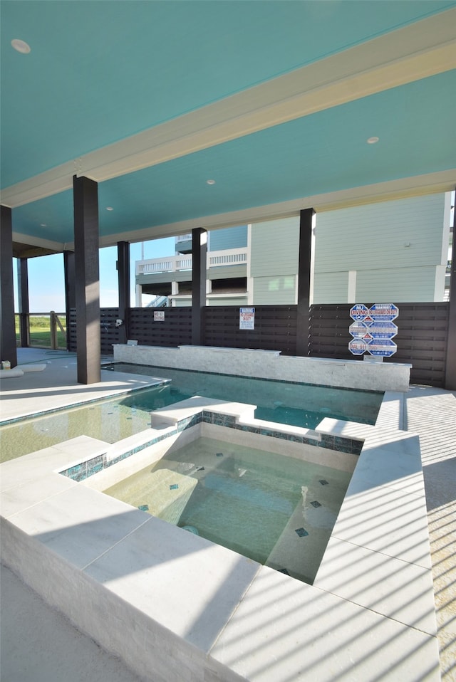 view of swimming pool featuring an indoor hot tub