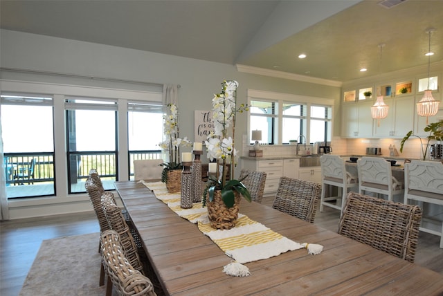 dining room with lofted ceiling, hardwood / wood-style floors, sink, and plenty of natural light