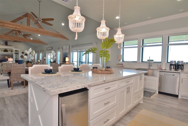 kitchen featuring plenty of natural light, a kitchen island, dishwasher, and ceiling fan with notable chandelier