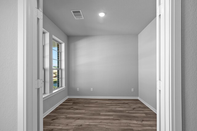 spare room featuring dark hardwood / wood-style flooring and plenty of natural light