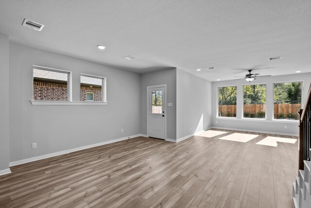 interior space featuring a textured ceiling, light hardwood / wood-style flooring, and ceiling fan