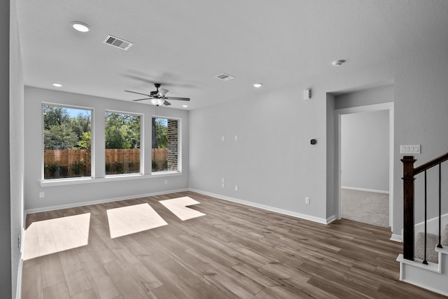 unfurnished living room featuring ceiling fan and hardwood / wood-style floors