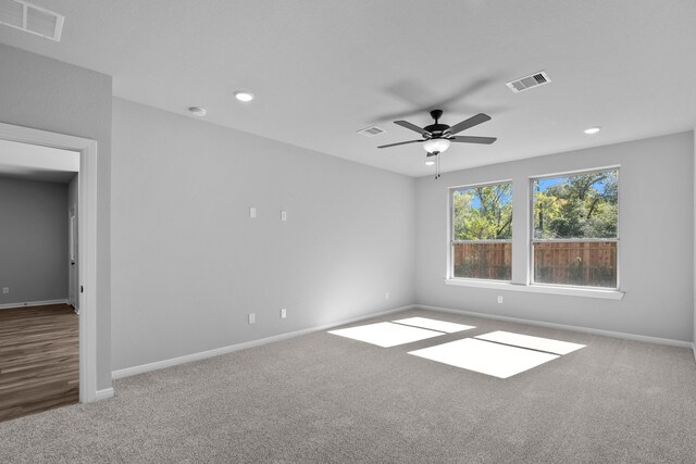 carpeted spare room with ceiling fan