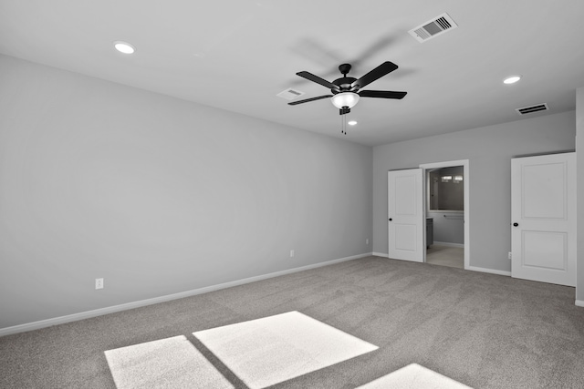 unfurnished bedroom with carpet flooring, a walk in closet, a closet, and ceiling fan