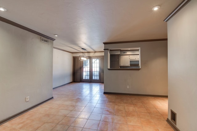 spare room with light tile patterned floors, crown molding, and french doors