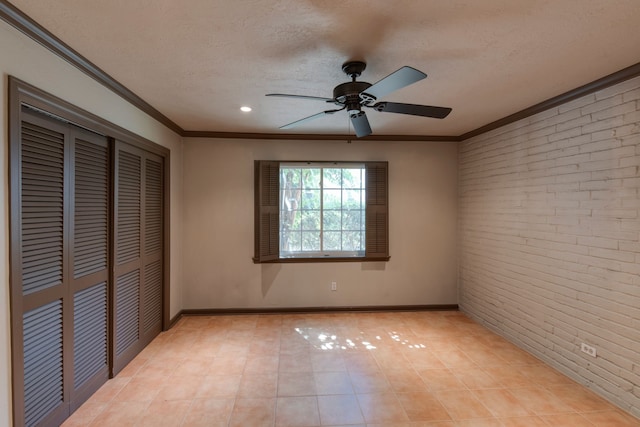 unfurnished bedroom with ornamental molding, brick wall, and a textured ceiling