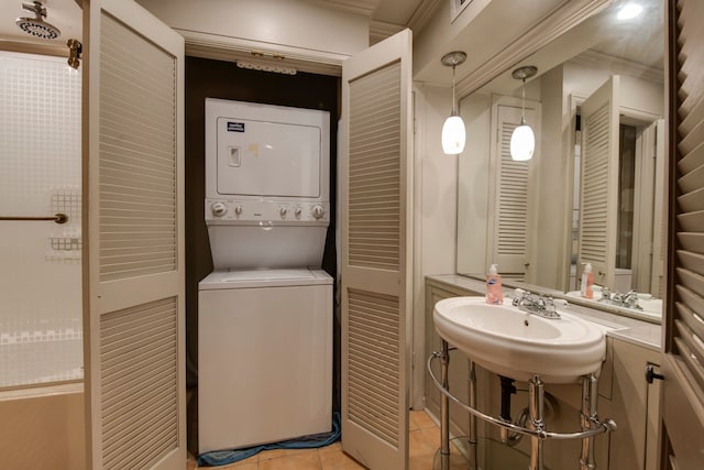 bathroom featuring crown molding, stacked washer and clothes dryer, sink, and tile patterned floors