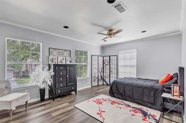 bedroom featuring hardwood / wood-style flooring, multiple windows, ornamental molding, and ceiling fan