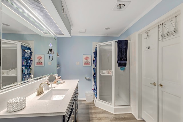 bathroom featuring crown molding, hardwood / wood-style floors, vanity, and an enclosed shower