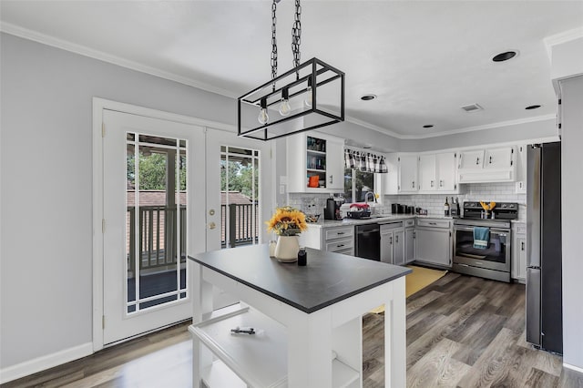 kitchen with appliances with stainless steel finishes, backsplash, dark wood-type flooring, decorative light fixtures, and white cabinetry