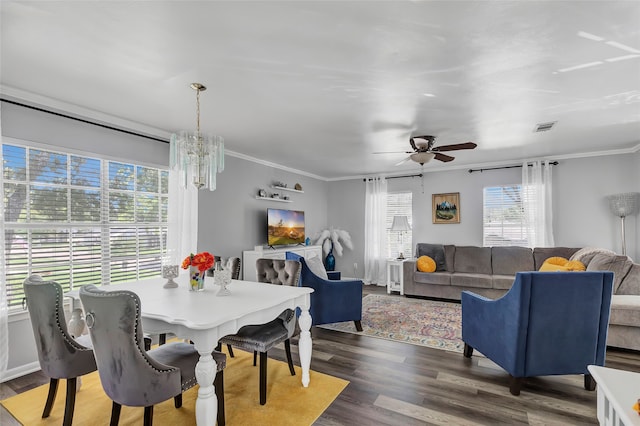 dining room with ceiling fan with notable chandelier, crown molding, and dark wood-type flooring