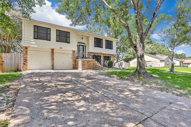 raised ranch featuring a front yard and a garage