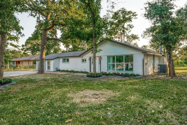 ranch-style house featuring a front yard and central AC