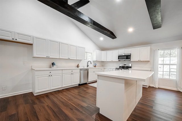 kitchen with lofted ceiling with beams, a center island, white cabinetry, appliances with stainless steel finishes, and dark hardwood / wood-style flooring