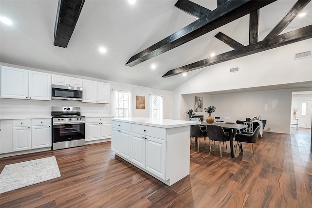 kitchen featuring white cabinets, appliances with stainless steel finishes, dark hardwood / wood-style floors, and a kitchen island