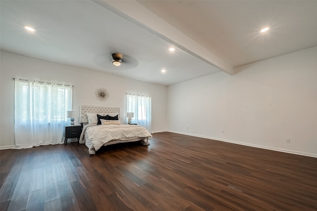 bedroom with beam ceiling, ceiling fan, a tile fireplace, and dark wood-type flooring