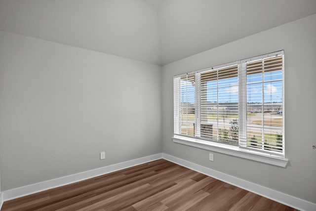 spare room featuring dark wood-style floors and baseboards