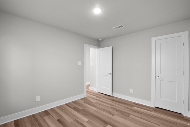 unfurnished room with baseboards, visible vents, and light wood-style flooring