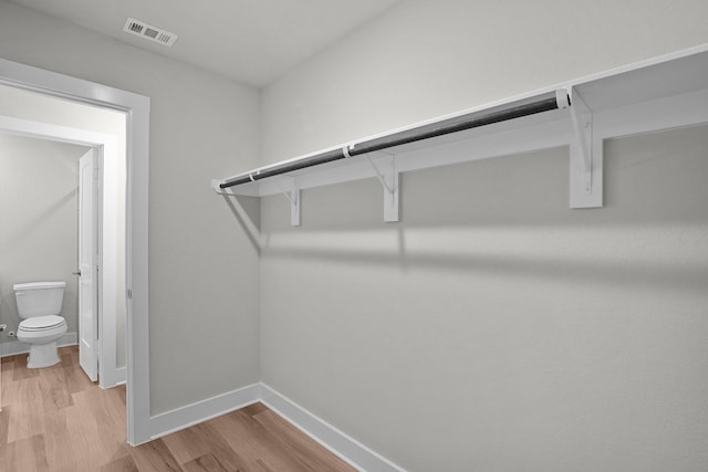 walk in closet with light wood-type flooring and visible vents