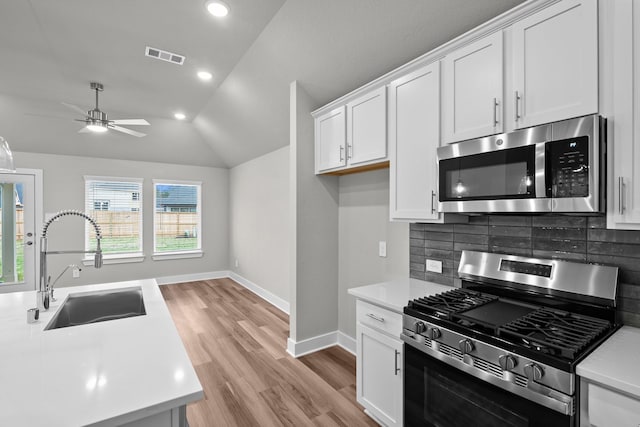 kitchen featuring light countertops, appliances with stainless steel finishes, a sink, and visible vents