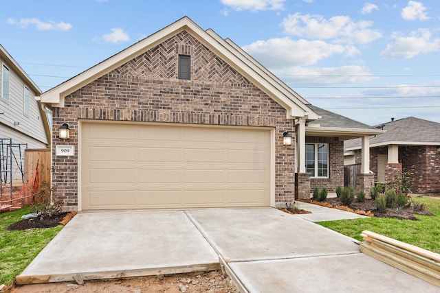 view of front facade with driveway, brick siding, an attached garage, and fence