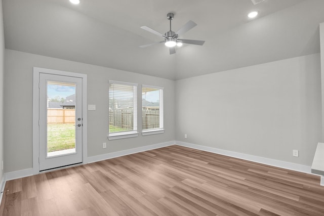 empty room featuring ceiling fan, light wood-style flooring, recessed lighting, baseboards, and vaulted ceiling