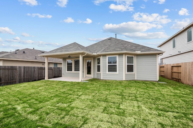 rear view of property with a shingled roof, a fenced backyard, a patio, and a lawn