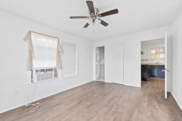 unfurnished bedroom featuring hardwood / wood-style flooring, connected bathroom, cooling unit, and ceiling fan