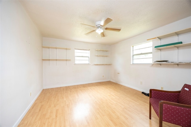 interior space featuring light wood-type flooring, ceiling fan, and a textured ceiling