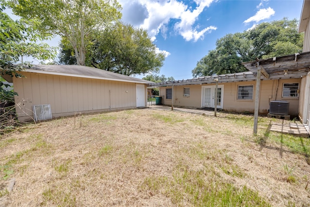 back of property featuring cooling unit, a lawn, and a pergola