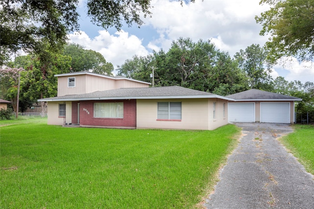 view of front of house with a garage, a front lawn, and an outdoor structure