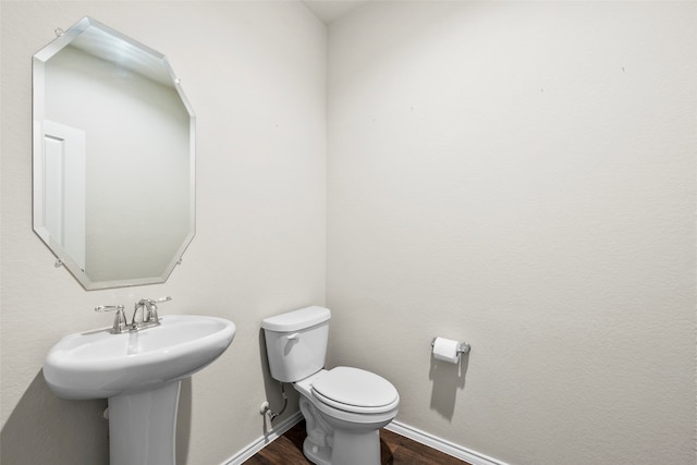 bathroom with hardwood / wood-style flooring and toilet