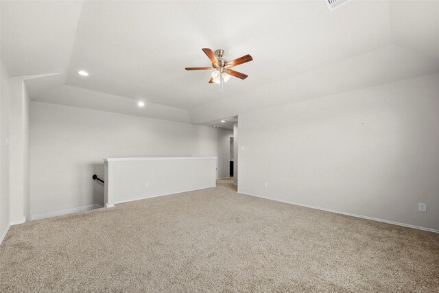 carpeted spare room featuring vaulted ceiling and ceiling fan