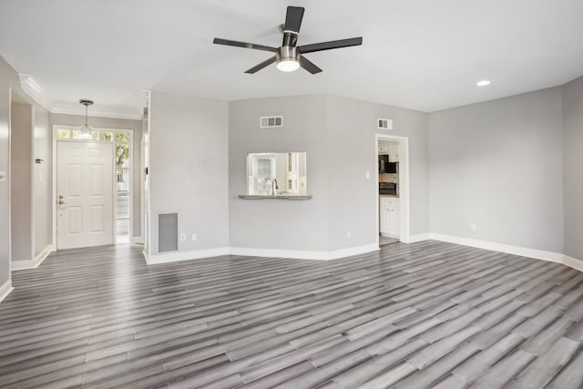 unfurnished living room featuring crown molding, dark hardwood / wood-style floors, sink, and ceiling fan