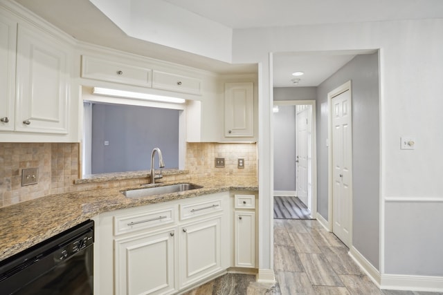 kitchen featuring dishwasher, backsplash, sink, light stone countertops, and white cabinetry