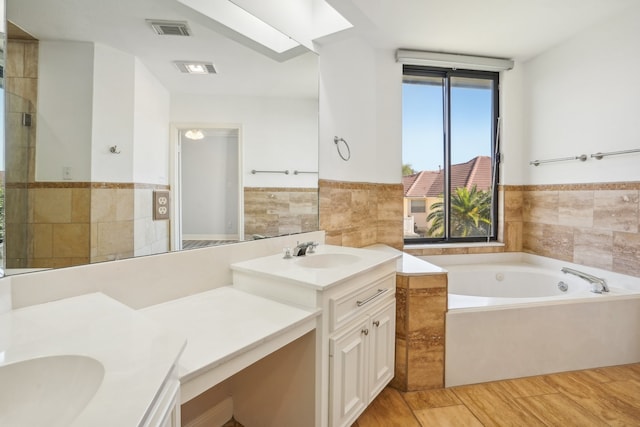 bathroom with vanity, tile walls, and plus walk in shower