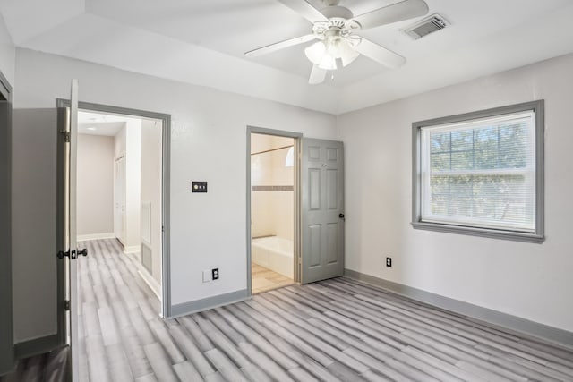 unfurnished bedroom featuring light hardwood / wood-style floors, a closet, a spacious closet, and ceiling fan