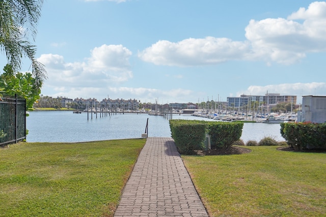 view of dock with a yard and a water view