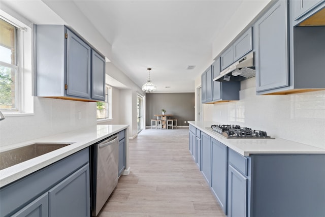 kitchen with sink, decorative light fixtures, an inviting chandelier, light wood-type flooring, and appliances with stainless steel finishes