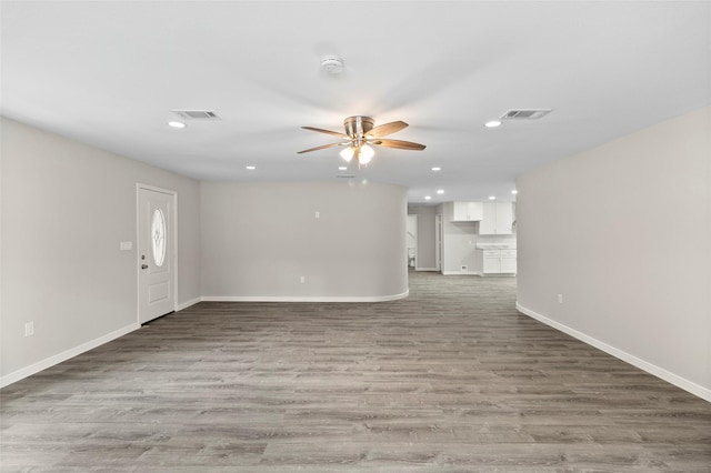 unfurnished living room with recessed lighting, visible vents, baseboards, and wood finished floors