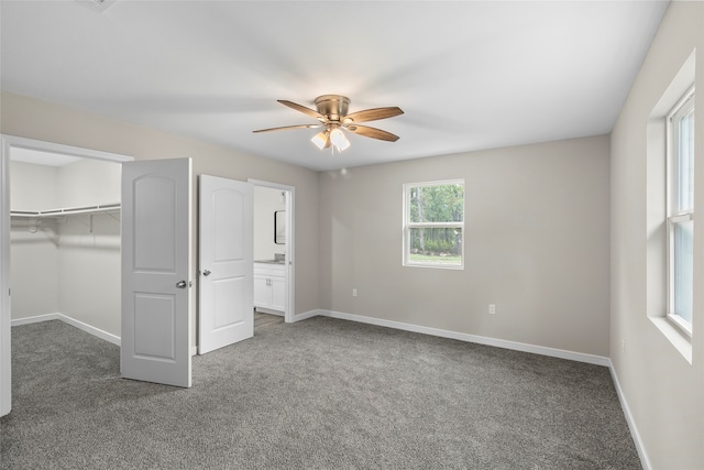 unfurnished bedroom featuring ensuite bathroom, ceiling fan, carpet flooring, and a closet