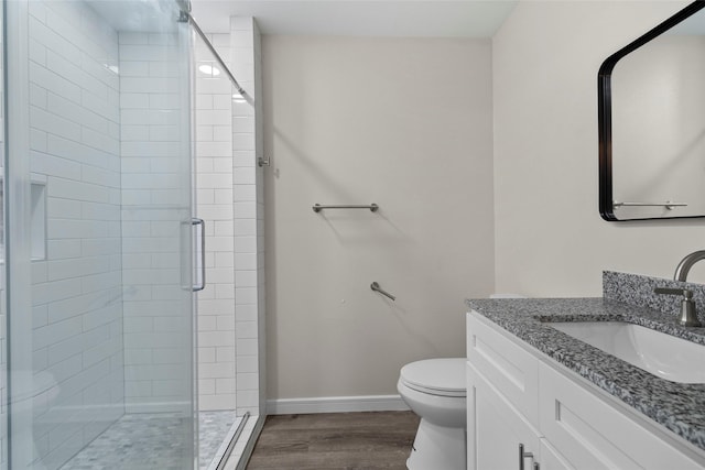 full bath with a stall shower, baseboards, toilet, and wood finished floors