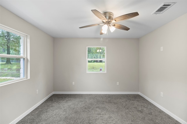 carpeted empty room with ceiling fan and plenty of natural light