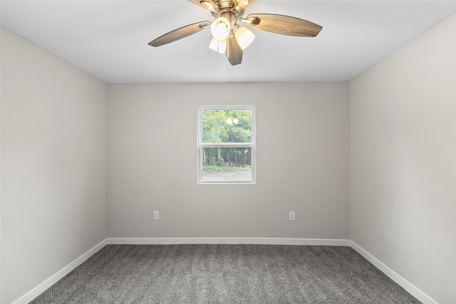 carpeted spare room with a ceiling fan and baseboards