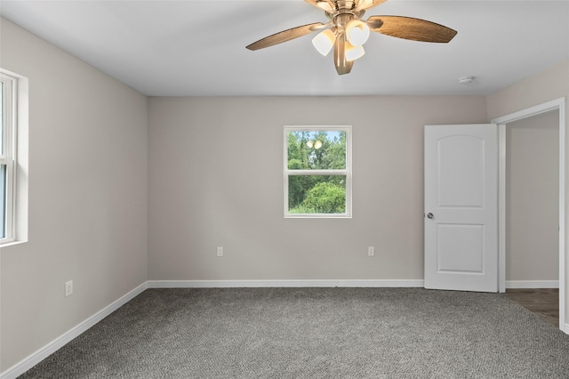 empty room with carpet, a ceiling fan, and baseboards