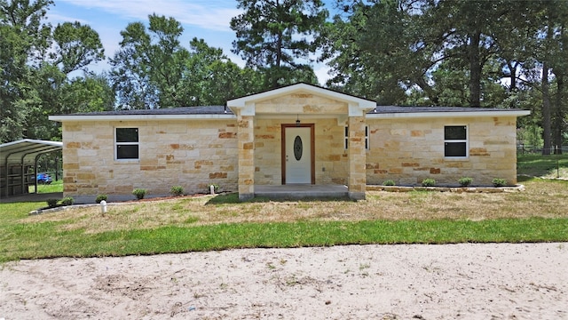 view of front of property featuring a front lawn and a carport