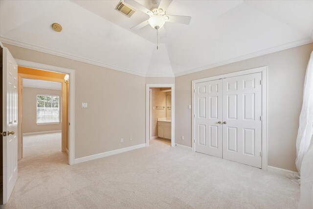 unfurnished bedroom with crown molding, light carpet, vaulted ceiling, ceiling fan, and a closet