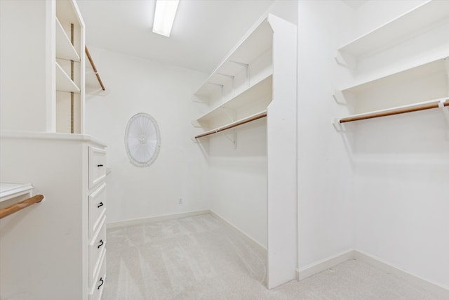 walk in closet featuring light colored carpet