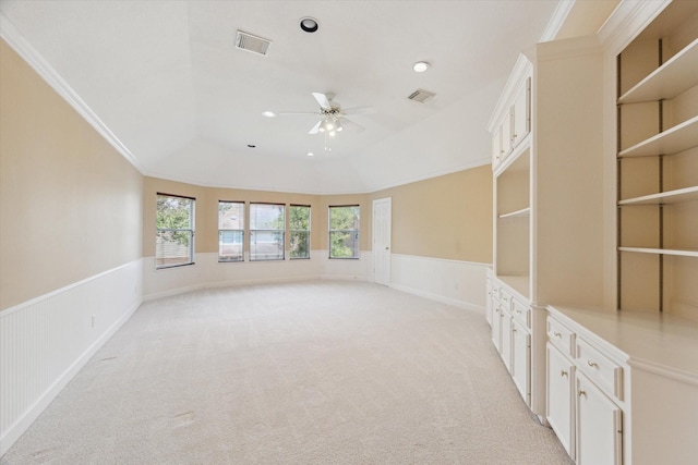 unfurnished room featuring ceiling fan, a tray ceiling, light carpet, and crown molding